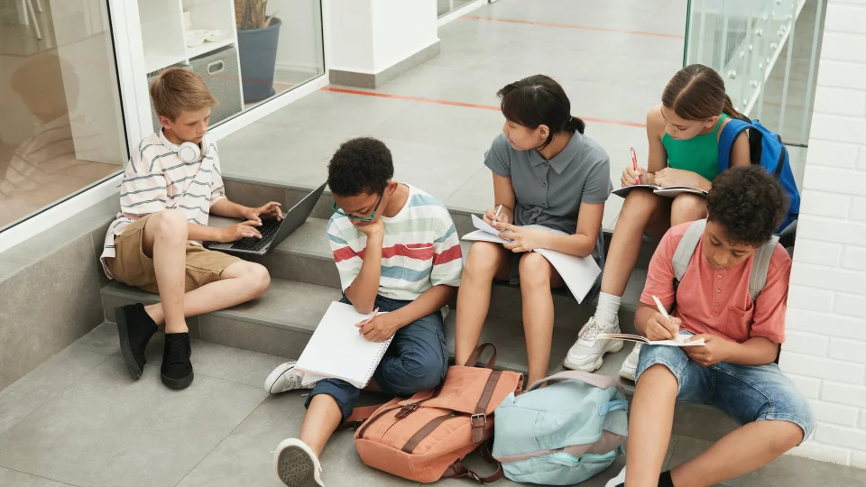 Gruppe von Schüler:innen lernen auf Stufen