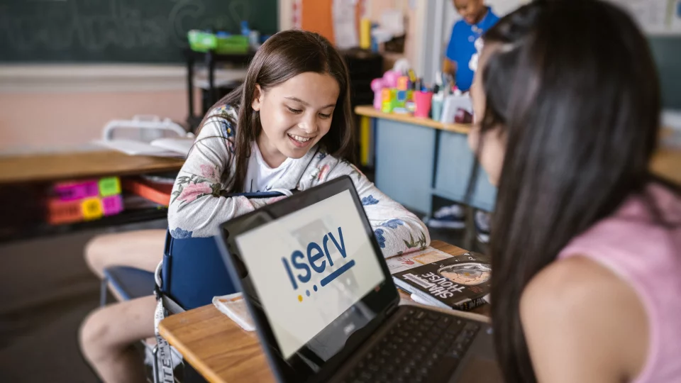 Zwei Schülerinnen an Laptop öffnen IServ